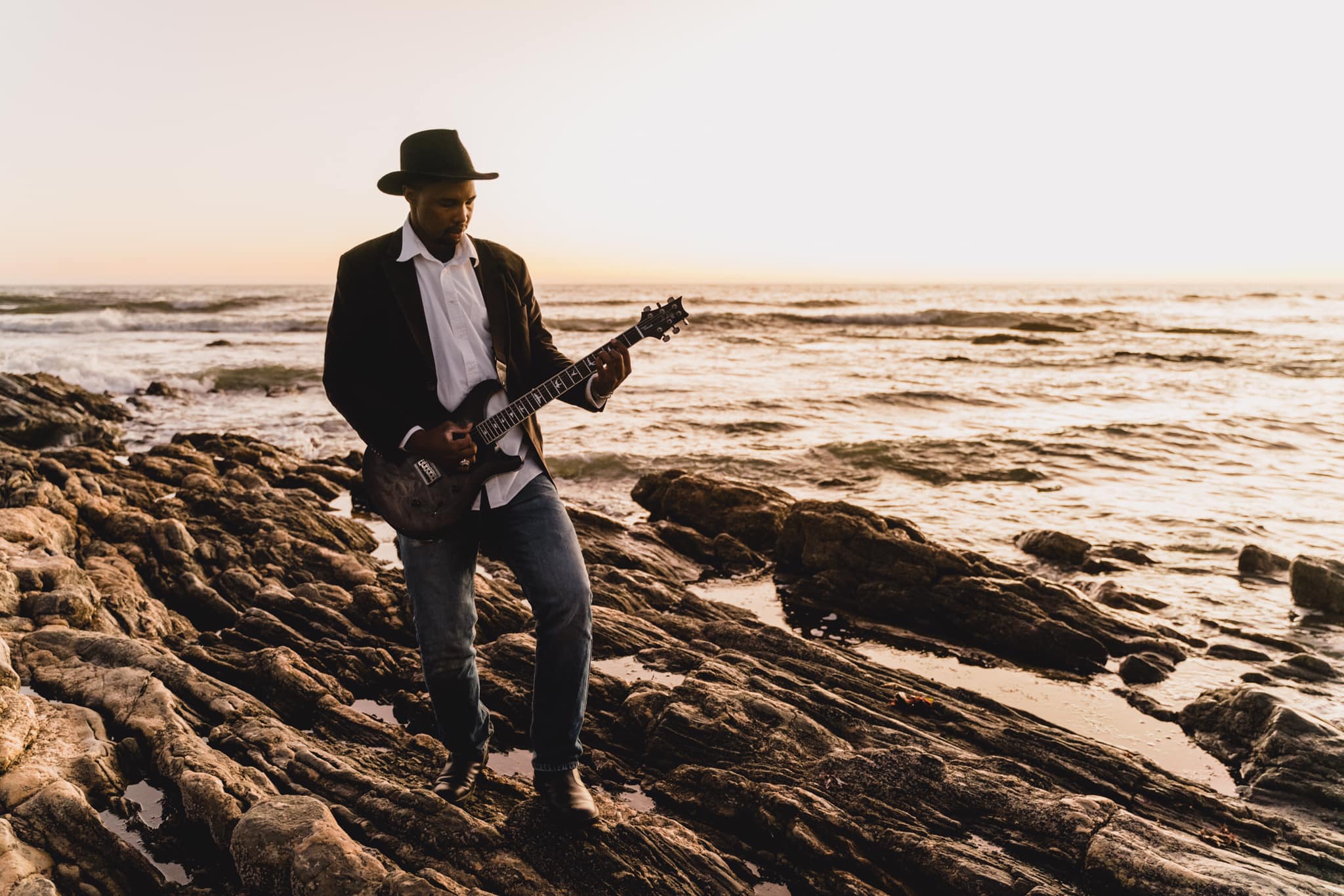 Sagarias Tsam playing blues music on a Namibian beach at sunset