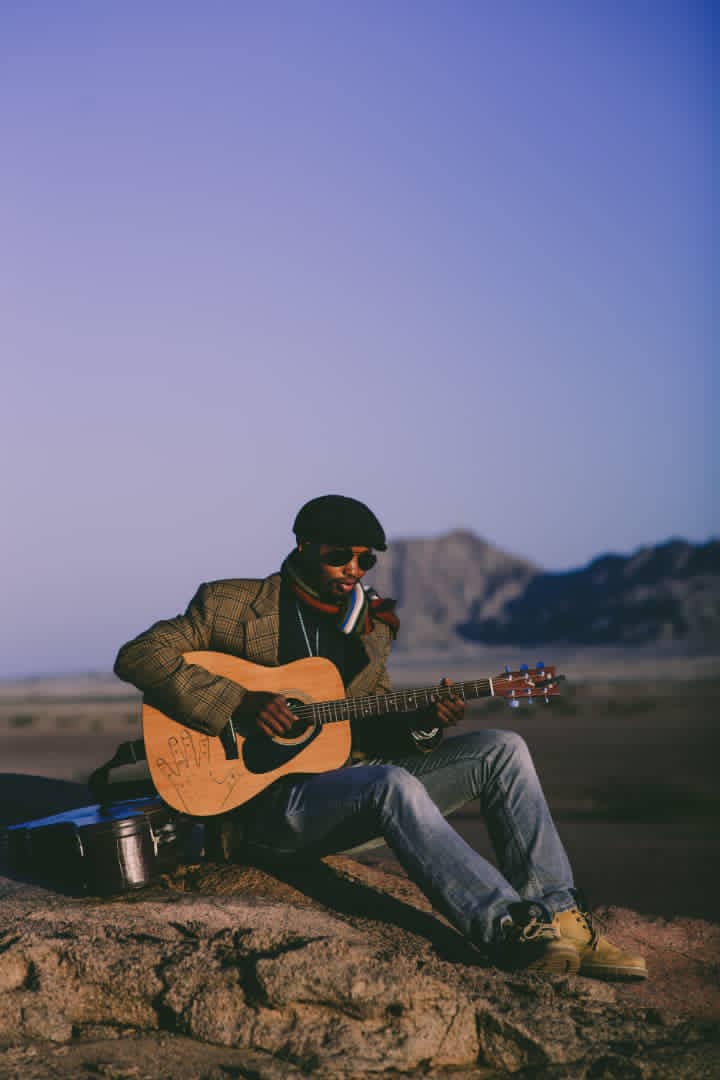 Sagarias Tsam playing accoustic guitar during twilight at the Spitzkoppe Namibia